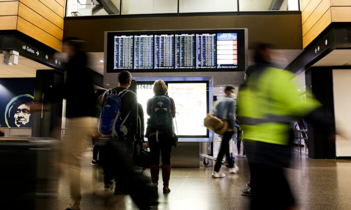 Travelers check a departures list at the ticketing level of Seattle-Tacoma International Airport in Seattle, on Nov. 24, 2021. (Lindsey Wasson/Reuters)