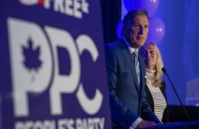 People's Party of Canada Leader Maxime Bernier and wife Catherine Letarte speaks from a podium to supporters during the PPC headquarters election night event in Saskatoon, Sask., Sept. 20, 2021. (The Canadian Press/Liam Richards)