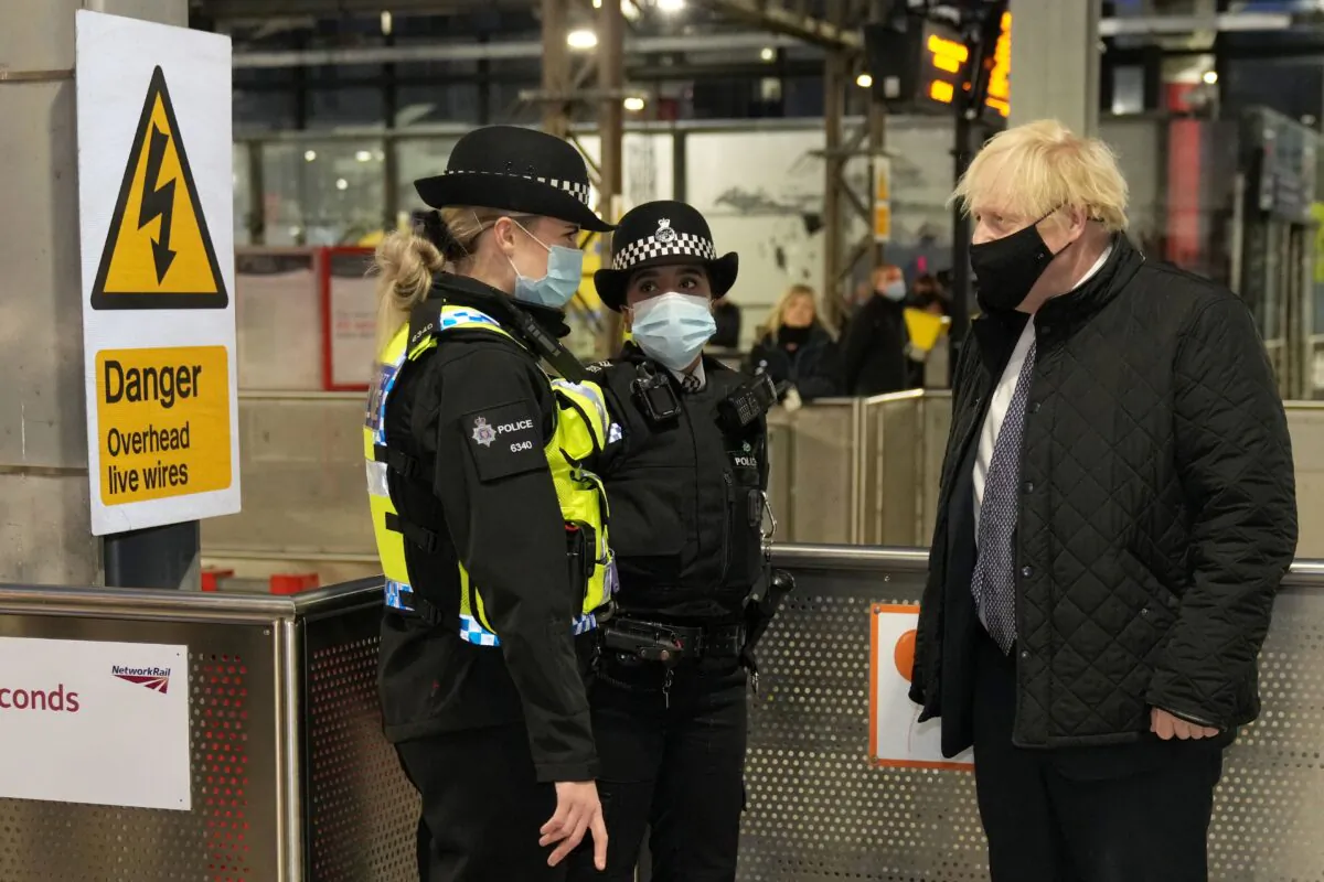British Prime Minister Boris Johnson (R) talks to British Transport Police officers at Liverpool Lime Street railway station as part of 'Operation Toxic' to infiltrate County Lines drug dealings, on Dec. 6, 2021. (Christopher Furlong /Pool/AFP via Getty Images)