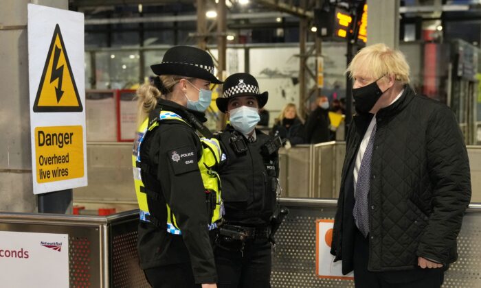 British Prime Minister Boris Johnson (R) talks to British Transport Police officers at Liverpool Lime Street railway station as part of 'Operation Toxic' to infiltrate County Lines drug dealings, on Dec. 6, 2021. (Christopher Furlong /Pool/AFP via Getty Images)
