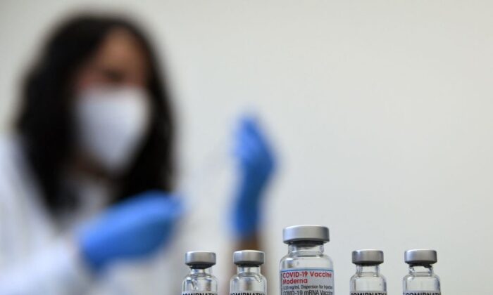 Vials of the COVID-19 vaccine by Moderna (C) and Pfizer/BioNTech against the novel coronavirus stand on a table in a vaccination center in Sonthofen, Germany, on Nov. 30, 2021. (Christof Stache/AFP via Getty Images)