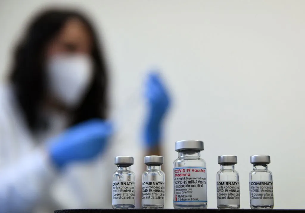 Vials of the COVID-19 vaccine by Moderna (C) and Pfizer/BioNTech against the novel coronavirus stand on a table in a vaccination center in Sonthofen, Germany, on Nov. 30, 2021. (Christof Stache/AFP via Getty Images)