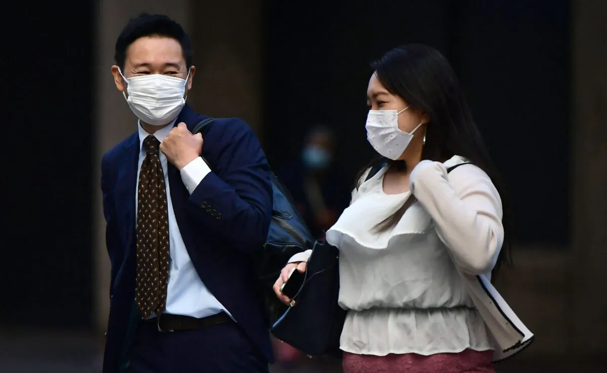 People wear face masks as they walk outdoors in Los Angeles, Calif., on Dec. 1, 2021. (Frederic J. Brown/AFP via Getty Images)