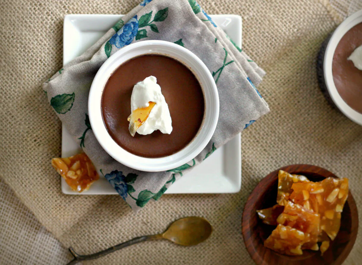 These chocolate custards get dressed up for the holidays with an infusion of Frangelico, Frangelico-laced whipped cream, and shards of hazelnut praline. (Lynda Balslev for Tastefood)