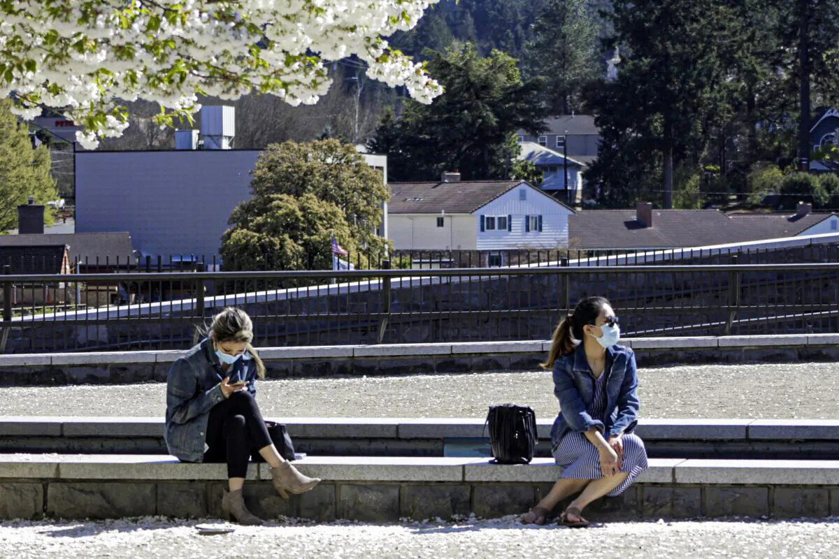 Residents wearing masks sit in downtown Lake Oswego, Ore., on April 11, 2021. (Gillian Flaccus/AP Photo)