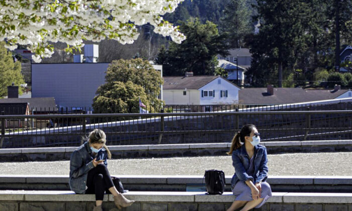 Residents wearing masks sit in downtown Lake Oswego, Ore., on April 11, 2021. (Gillian Flaccus/AP Photo)