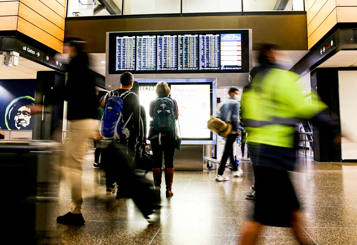 Travelers check a departures list at the ticketing level of Seattle-Tacoma International Airport in Seattle, on Nov. 24, 2021. (Lindsey Wasson/Reuters)