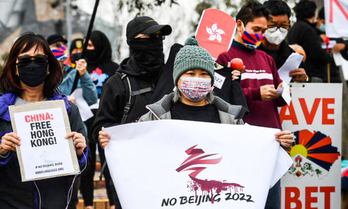 Activists including members of the local Hong Kong, Tibetan, and Uyghur communities hold up banners and placards in Melbourne on June 23, 2021, calling on the Australian government to boycott the 2022 Beijing Winter Olympics over China's human rights record. (William West/AFP via Getty Images)