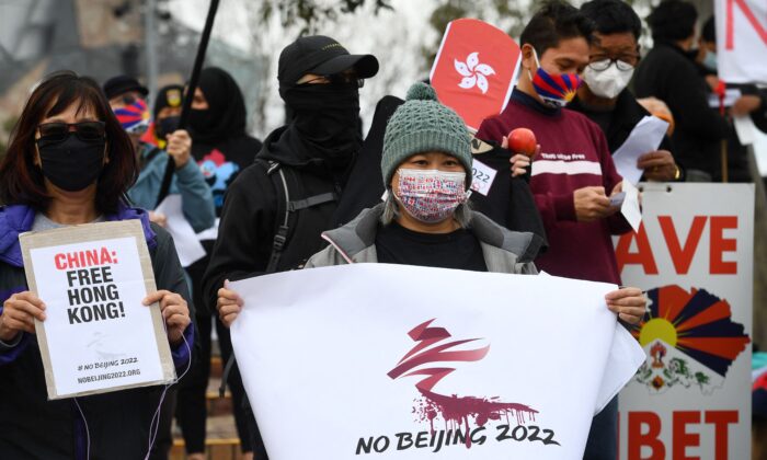 Activists including members of the local Hong Kong, Tibetan and Uyghur communities hold up banners and placards in Melbourne on June 23, 2021, calling on the Australian government to boycott the 2022 Beijing Winter Olympics over China's human rights record. (William West/AFP via Getty Images)