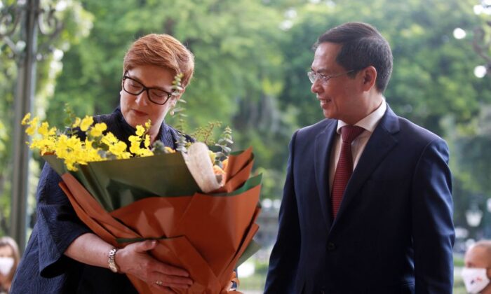Australia's Foreign Minister Marise Payne (L) recieves flowers from her Vietnamese counterpart Bui Thanh Son (R) at the Government Guest House in Hanoi on November 9, 2021. (LUONG THAI LINH/POOL/AFP via Getty Images)
