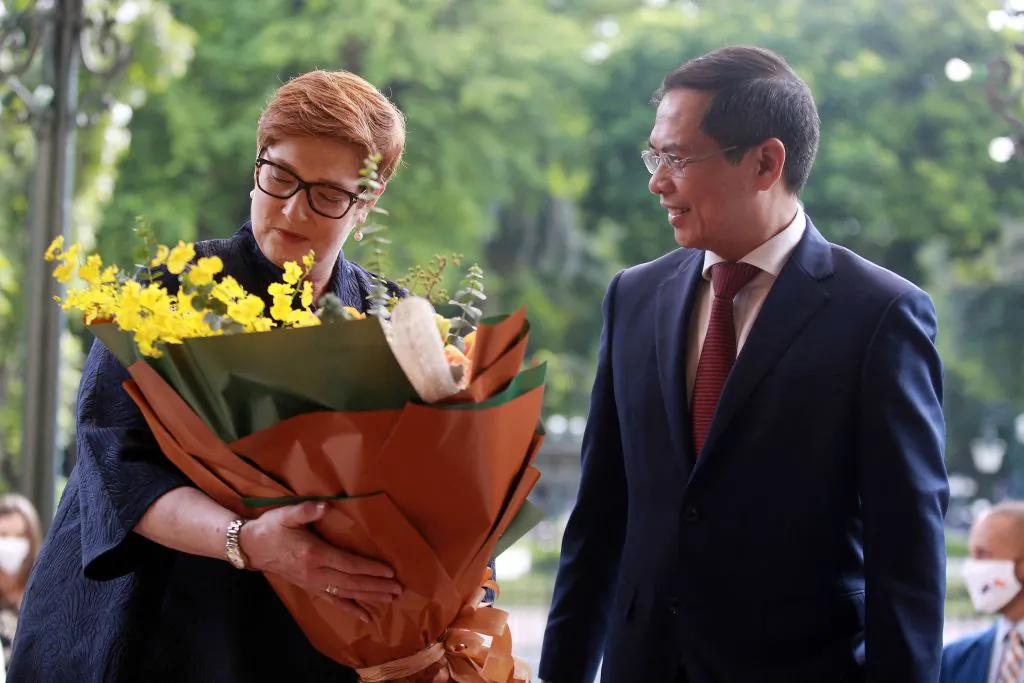 Australia's Foreign Minister Marise Payne (L) recieves flowers from her Vietnamese counterpart Bui Thanh Son (R) at the Government Guest House in Hanoi on November 9, 2021. (LUONG THAI LINH/POOL/AFP via Getty Images)