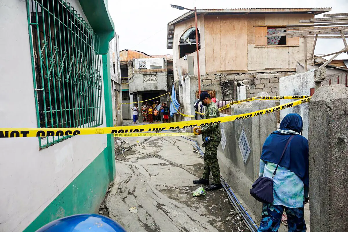 A police officer secures an area where Mayor Darussalam Lajid of Al-Barka town was killed and Mayor Alih Sali of Akbar town was wounded while walking at Baliwasan village in Zamboanga city, southern Philippines, on Dec. 6, 2021. (AP Photo)