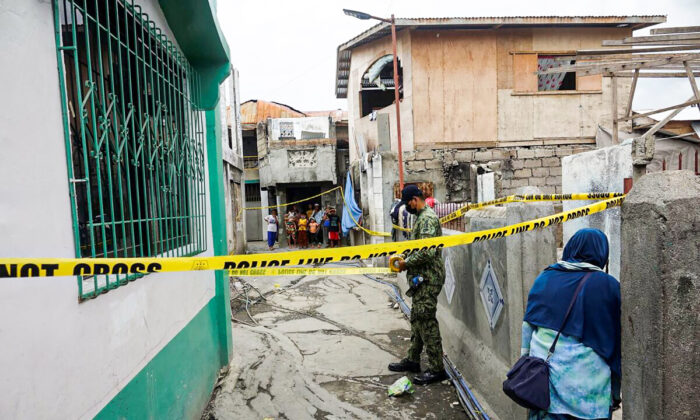 A police officer secures an area where Mayor Darussalam Lajid of Al-Barka town was killed and Mayor Alih Sali of Akbar town was wounded while walking at Baliwasan village in Zamboanga city, southern Philippines, on Dec. 6, 2021. (AP Photo)