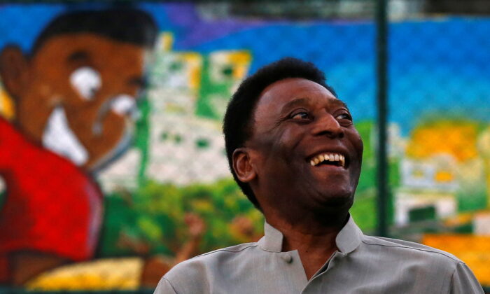 Brazilian soccer legend Pele laughs during the inauguration of a refurbished soccer field at the Mineira slum in Rio de Janeiro, on Sept. 10, 2014. (Ricardo Moraes/Reuters)