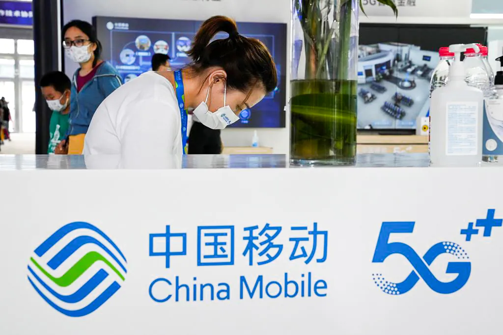 A worker waits for visitors to the China Mobile booth in Beijing, China, on Sept. 5, 2021. (Ng Han Guan/AP Photo)