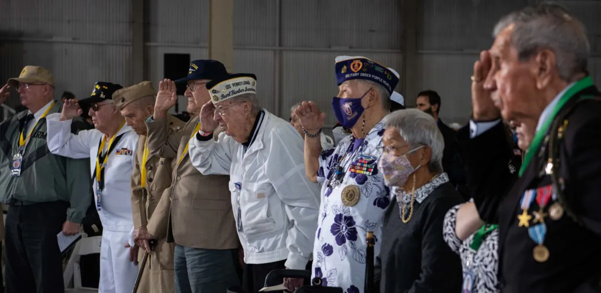 Pearl Harbor survivors and World War II veterans, along with family and friends, render honors during the national anthem at the 80th Anniversary Pearl Harbor Remembrance in Pearl Harbor, Hawaii, on Dec. 7, 2021. (U.S. Navy photo by Mass Communication Specialist 1st Class Jessica Gray)