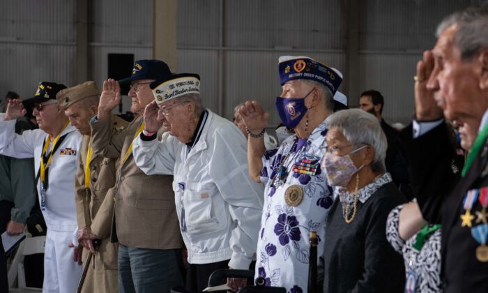 Pearl Harbor survivors and World War II veterans, along with family and friends, render honors during the national anthem at the 80th Anniversary Pearl Harbor Remembrance in Pearl Harbor, Hawaii, on Dec. 7, 2021. (U.S. Navy photo by Mass Communication Specialist 1st Class Jessica Gray)