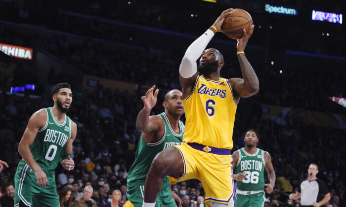Los Angeles Lakers forward LeBron James (6) drives past Boston Celtics center Al Horford, center, during the second half of an NBA basketball game in Los Angeles on Dec. 7, 2021. (AP Photo/Marcio Jose Sanchez)