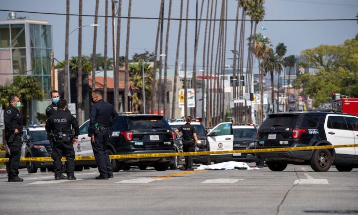 LAPD police officers stand at the scene of a fatal shooting involving police on the corner of Fairfax Avenue and Sunset Boulevard, Los Angeles on April 24, 2021. (Valerie Macon/AFP via Getty Images)