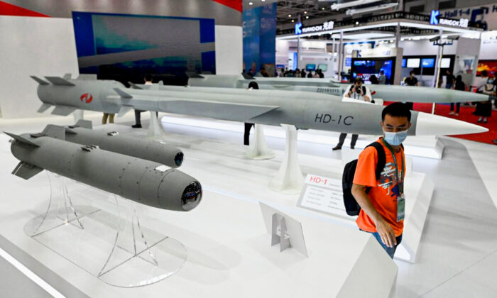 A man walks among supersonic cruise missiles at the 13th China International Aviation and Aerospace Exhibition in Zhuhai, in southern China's Guangdong Province, on Sept. 28, 2021. (Noel Celis/AFP via Getty Images)