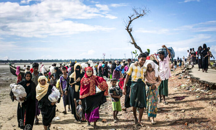 Rohingya refugees make their way along a beach after arriving by boat at Shah Porir Dip, Bangladesh, on Sept. 14, 2017. (Allison Joyce/Getty Images)