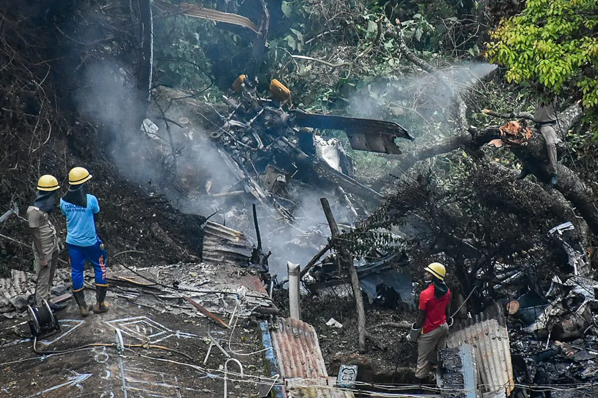 Firemen and rescue workers stand next to the debris of an IAF Mi-17V5 helicopter crash site in Coonoor, Tamil Nadu, on Dec. 8, 2021. (AFP via Getty Images)