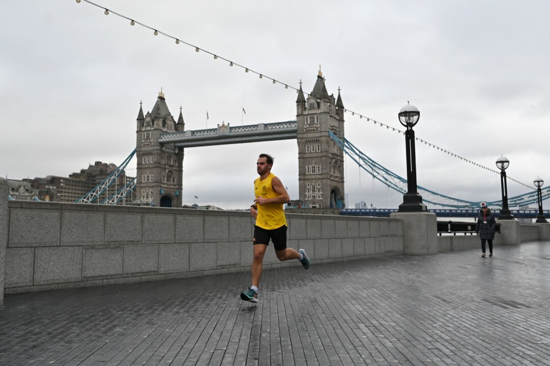 A jogger runs along the bank of the River Thames with Tower Bridge in the background in London on Jan. 12, 2021. (Justin Tallis/AFP via Getty Images)