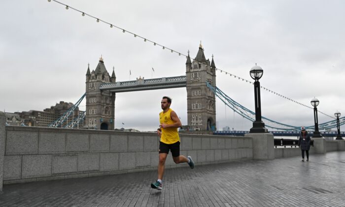 A jogger runs along the bank of the River Thames with Tower Bridge in the background in London on Jan. 12, 2021. (Justin Tallis/AFP via Getty Images)