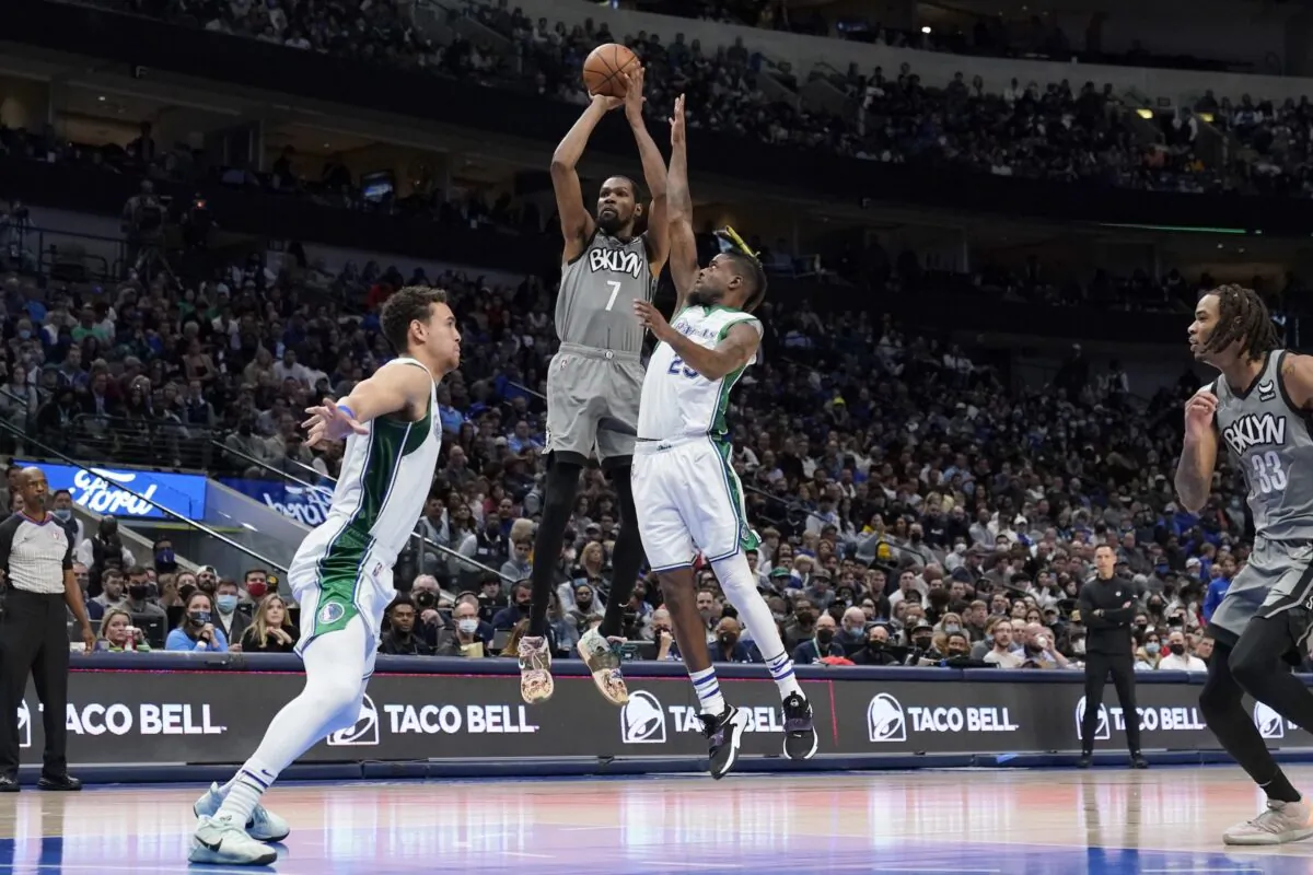 Dallas Mavericks' Dwight Powell (L) and Reggie Bullock (R) defend as Brooklyn Nets forward Kevin Durant (7) takes a shot in the second half of an NBA basketball game in Dallas, on Dec. 7, 2021. (Tony Gutierrez/AP Photo)