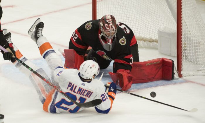 New York Islanders center Kyle Palmieri (21) is knocked down as he shoots on Ottawa Senators goalie Filip Gustavsson (32) during an NHL game at the Canadian Tire Centre, in Ottawa, Ontario, Canada, on Dec. 7, 2021. (Marc DesRosiers/USA TODAY Sports via Field Level Media)