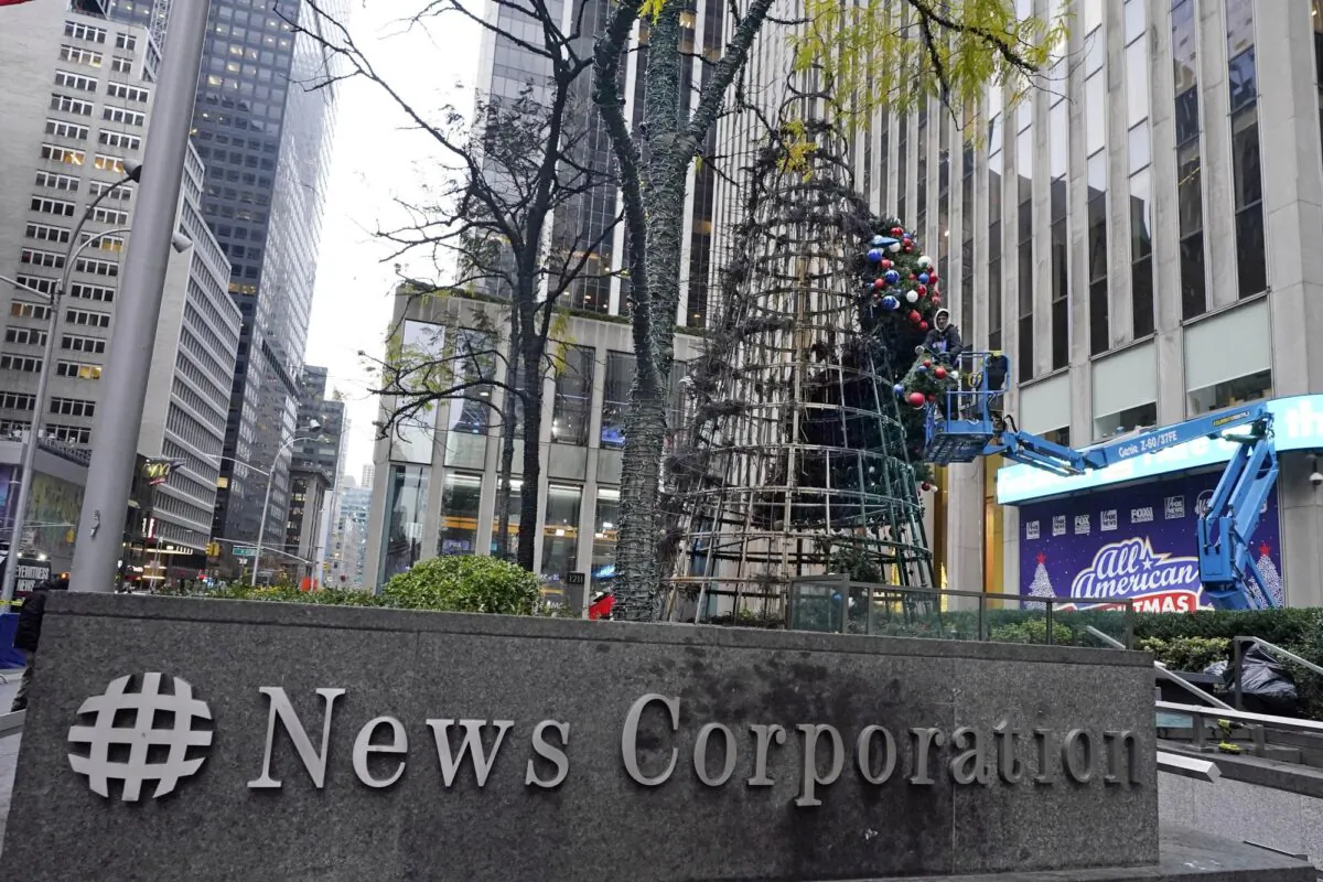 A worker disassembles a Christmas tree outside Fox News headquarters, in N.Y.C., on Dec. 8, 2021. (Richard Drew/AP Photo)