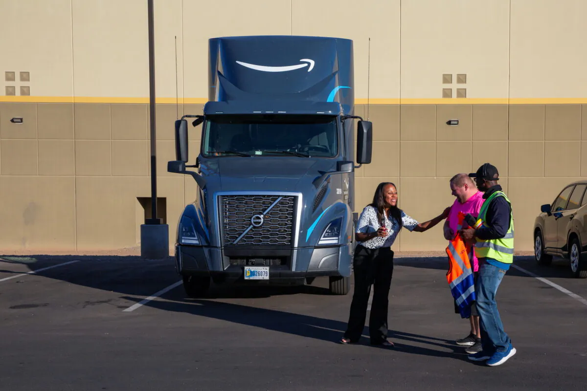 Amazon Freight Partner Ebony McKinley talks with truck drivers Ian Crocker and Ray Land during a shift change at Seven Strong Trucking in Phoenix, on Dec. 2, 2021. (Caitlin O'Hara/Reuters)
