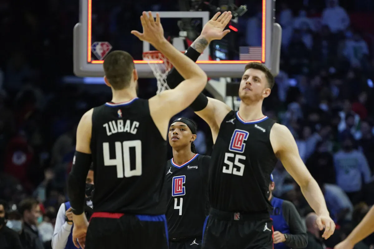 Los Angeles Clippers guard Brandon Boston Jr. (4) watches as center Ivica Zubac (40) and center Isaiah Hartenstein (55) celebrate after a 114-111 win over the Boston Celtics in an NBA basketball game in in Los Angeles, on Dec. 8, 2021. (Ashley Landis/AP Photo)