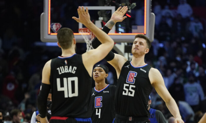 Los Angeles Clippers guard Brandon Boston Jr. (4) watches as center Ivica Zubac (40) and center Isaiah Hartenstein (55) celebrate after a 114-111 win over the Boston Celtics in an NBA basketball game in in Los Angeles, on Dec. 8, 2021. (Ashley Landis/AP Photo)