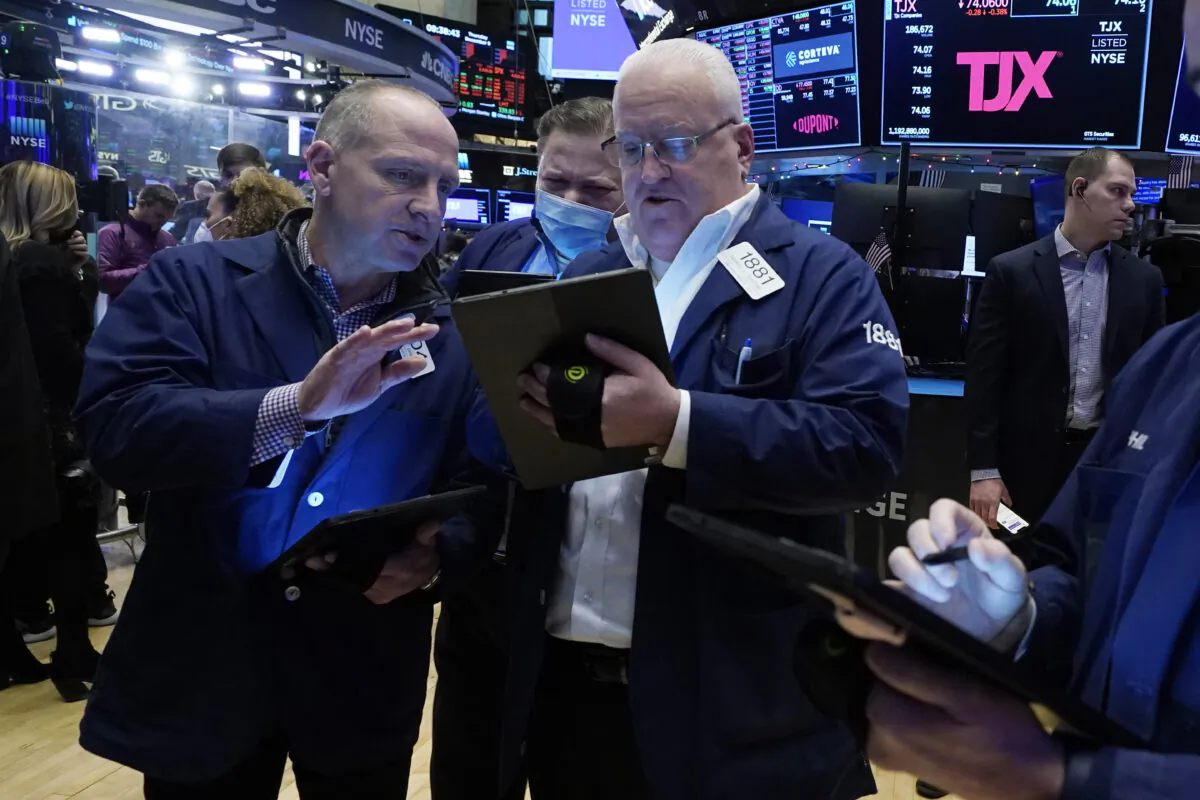 Traders Michael Urkonis (L) John Santiago (C) and Thomas Ferrigno work on the floor of the New York Stock Exchange, on Dec. 9, 2021. (Richard Drew/AP Photo)