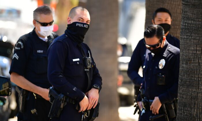 Los Angeles Police Department (LAPD) officers wear facial covering while monitoring an "Open California" rally in downtown Los Angeles, on April 22, 2020. (FREDERIC J. BROWN/AFP via Getty Images)