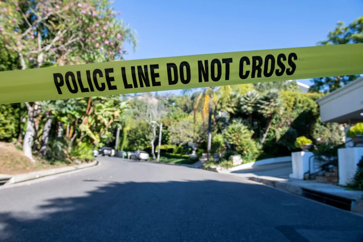 In this file photo, a yellow police tape blocks access to the scene of a burglary and shooting in Beverly Hills, Calif., on Dec. 1, 2021.  (Valerie Macon/AFP via Getty Images)