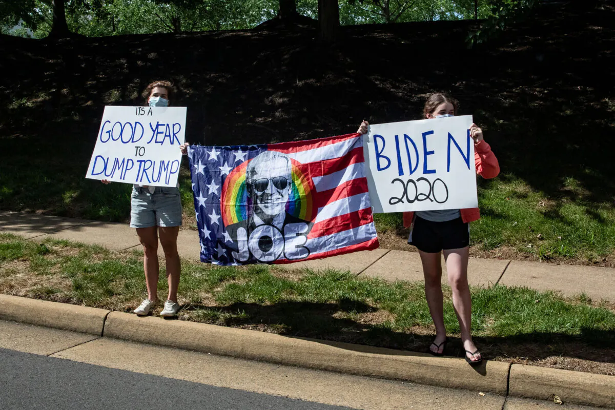 Supporters of Democratic presidential candidate Joe Biden and protestors of President Donald Trump stand along the road as President Trump's motorcade leaves his golf club, Trump National, in Sterling, Va., on Aug. 30, 2020. (Samuel Corum/AFP/Getty Images/TNS)