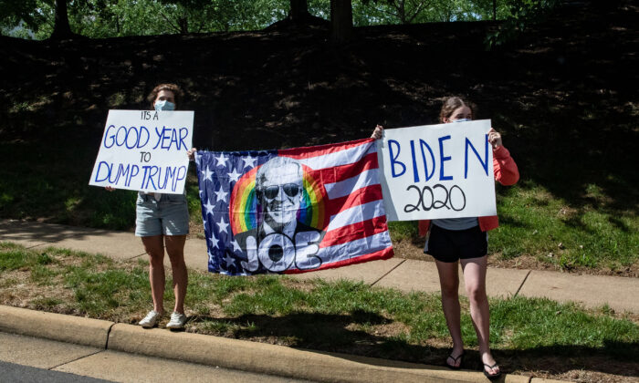 Supporters of Democratic presidential candidate Joe Biden and protestors of President Donald Trump stand along the road as President Trump's motorcade leaves his golf club, Trump National, in Sterling, Va., on Aug. 30, 2020. (Samuel Corum/AFP/Getty Images/TNS)
