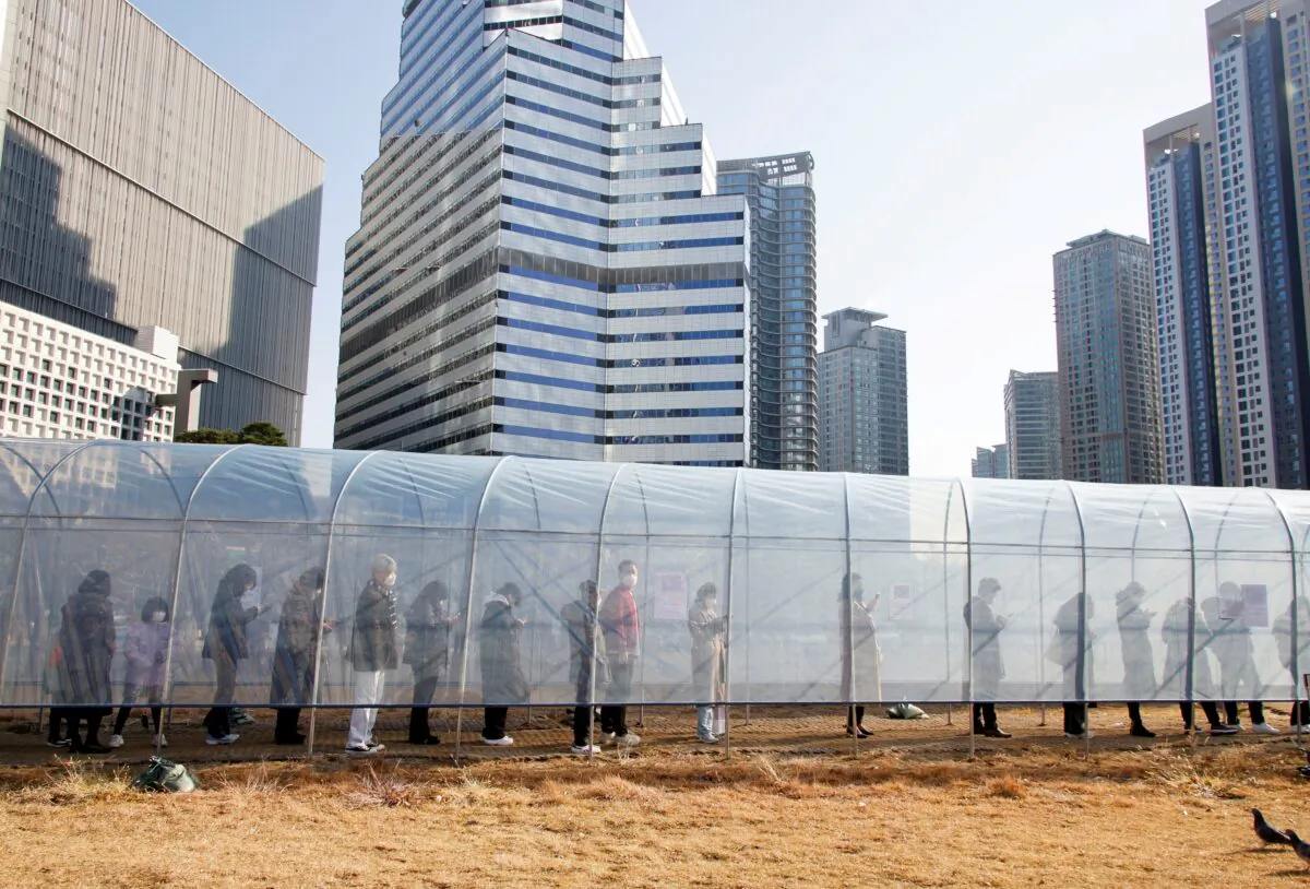 People wait in a line to undergo COVID-19 testing at a railway station in Seoul, South Korea, on Dec. 8, 2021. (Heo Ran/Reuters)