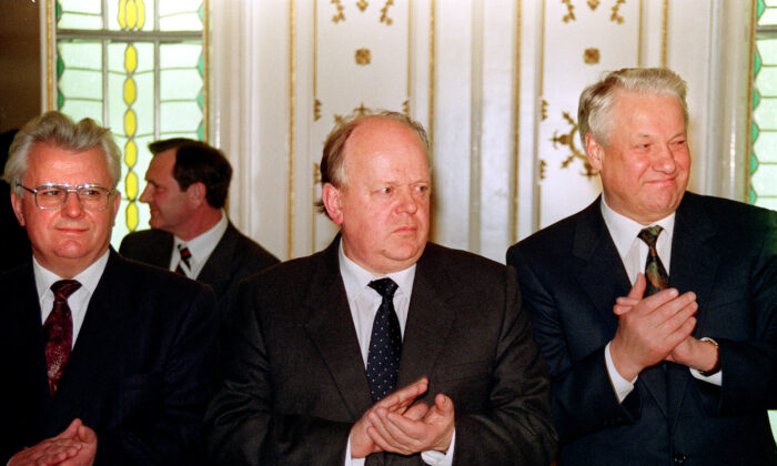 Ukrainian President Leonid Kravchuk (L), Belarus's Supreme Soviet Chairman Stanislav Shushkevich (C), and Russian President Boris Yeltsin (R) stand for applause after signing a mutual assistance agreement stating that "the Soviet Union as a geopolitical reality [and] a subject of international law has ceased to exist" on Dec. 8, on 1991. (Novosti/AFP via Getty Images)