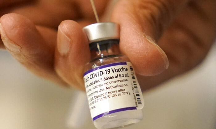 A Pfizer COVID-19 vaccine was transferred into a syringe, Thursday, Dec. 2, 2021, at a mobile vaccination clinic in Worcester, Mass. (AP Photo/Steven Senne, File)