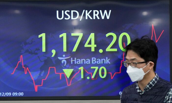 A currency trader walks by a screen showing the foreign exchange rate between U.S. dollar and South Korean won at a foreign exchange dealing room in Seoul, South Korea, on Dec. 9, 2021. (Lee Jin-man/AP Photo)