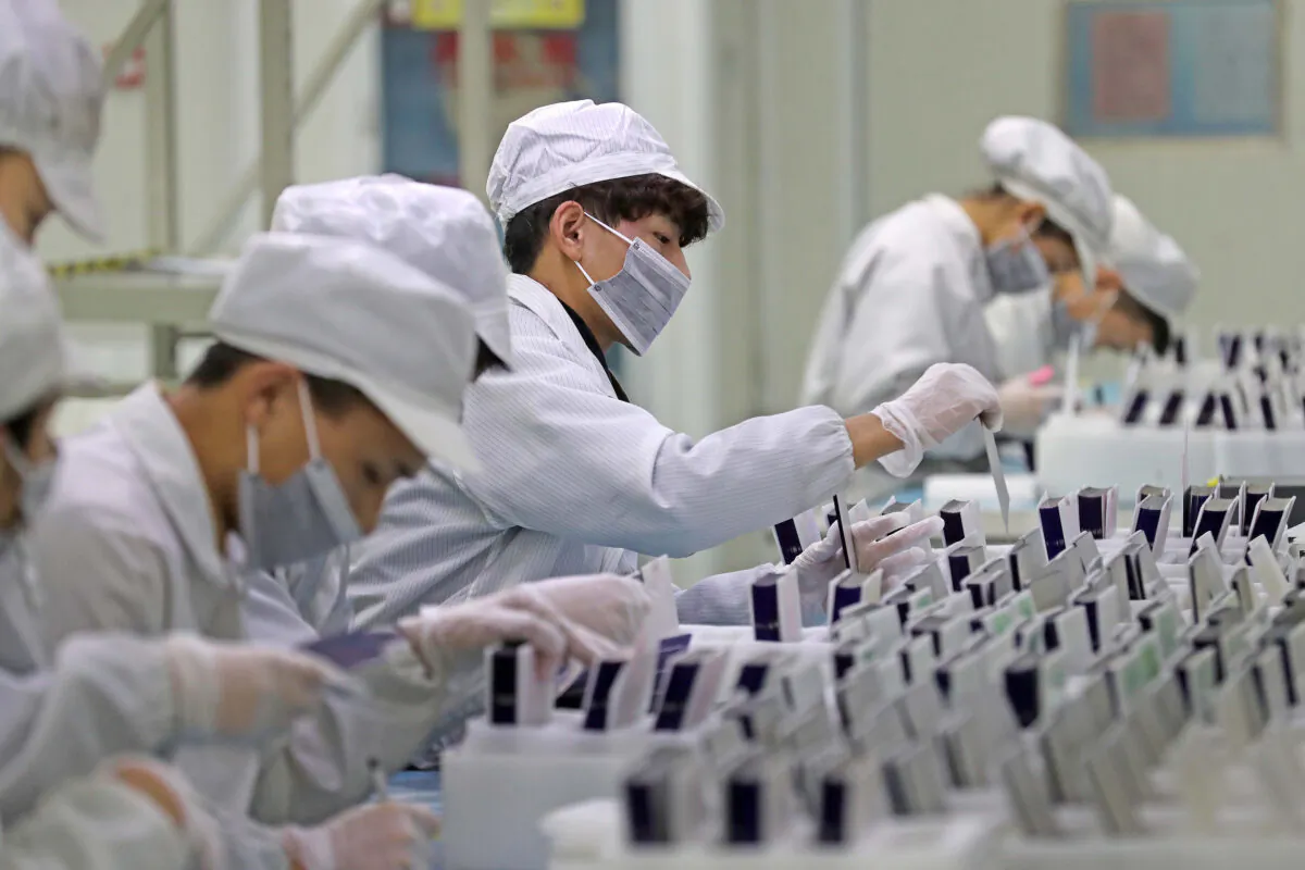 Workers at a production line manufacturing solar photovoltaic components at a factory in Zhejiang Province, China, on Feb. 12, 2019. (Lin Yunlong/Zhejiang Daily via Reuters)