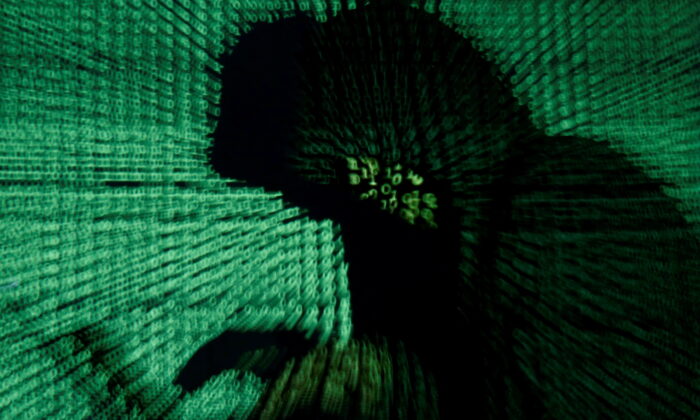 A man holds a laptop computer as cyber code is projected on him in this illustration picture taken on May 13, 2017. (Kacper Pempel/Reuters)