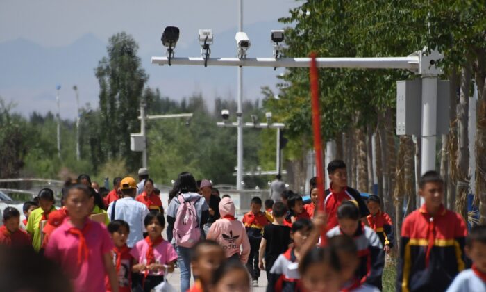This photo taken on June 4, 2019 shows schoolchildren walking below surveillance cameras in Akto, south of Kashgar, in China's western Xinjiang region. (Greg Baker/AFP via Getty Images)