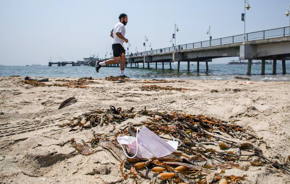 A man runs next to a discarded face mask in the Belmont Veterans Memorial Pier in Long Beach, California on Aug. 22, 2020. (Apu Gomes/AFP via Getty Images)