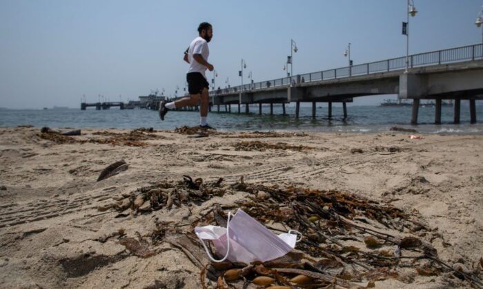 A man runs next to a discarded face mask in the Belmont Veterans Memorial Pier in Long Beach, California on Aug. 22, 2020. (Apu Gomes/AFP via Getty Images)