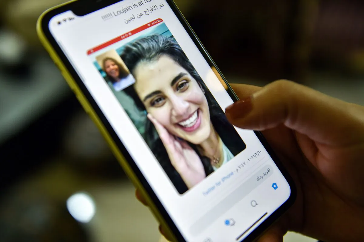 This picture taken Feb. 10, 2021 in Saudi Arabia's capital Riyadh shows a woman viewing a tweet posted by the sister of Saudi activist Loujain al-Hathloul, Lina, showing a screenshot of them having a video call following Hathloul's release after nearly three years in detention. Saudi authorities on February 10 released the prominent women's rights activist, her family said. (Fayez Nureldine/AFP via Getty Images)