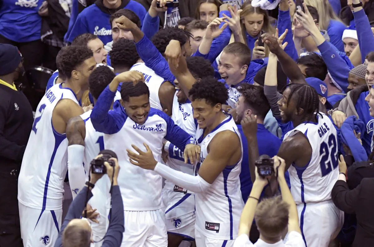 Seton Hall players celebrate with students after the team defeated Texas in an NCAA college basketball game, in Newark, N.J., on Dec. 9, 2021. (Bill Kostroun/AP Photo)